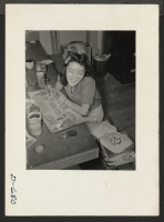 [recto] Painting a sign for the Harvest Festival to be held November 26, 1942 (Thanksgiving day). Yo Shimizu. Present occupation: student. Former occupation: student. Former residence: Vacaville, California. ;  Photographer: Stewart, Francis ;  Rivers, Arizon