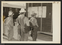 [recto] Bulletins in English and in Japanese keep evacuees posted at this War Relocation Authority center. ;  Photographer: Albers, Clem ;  Manzanar, California.