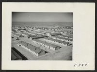 [recto] On a quiet Sunday afternoon at the Amache Center, the day is calm and the warm December sun invites center residents from their barracks homes. ;  Photographer: Parker, Tom ;  Amache, Colorado.