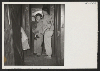[recto] A W.R.A. warden is shown assisting transferees to detrain upon their arrival at the Tule Lake station. This young child shows his resentment at being aroused from a sound slumber. ;  Photographer: Mace, Charles E. ; , .