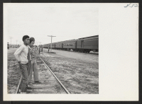 [recto] Watching arrival of train from Tule Lake.--INCOMING ;  Photographer: Aoyama, Bud ;  Heart Mountain, Wyoming.