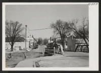 [recto] Approaching McHenry, Illinois from the east, the newcomer is greeted by this scene of one of the business blocks. The town is built along the Des Plaines River and is typical of Illinois farm towns. ;  Photographer: Mace, Charles E. ;  McHenry, Illino