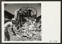 [recto] Tule Lake, Newell, Calif.--Evacuees distribute scrap lumber to each block. This scrap will be used by the residents to construct furniture for their apartments and also for firewood. ;  Photographer: Stewart, Francis ;  Newell, California.
