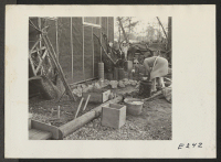 [recto] Mrs. T. Arima busily prepares her doorstep garden in Block 7. Besides odd plants and stump arrangements, there will be a pool with goldfish. ;  Photographer: Parker, Tom ;  Denson, Arkansas.