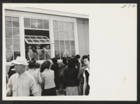[recto] OUTGOING--Shaking farewell through window of high school building. ;  Photographer: Aoyama, Bud ;  Heart Mountain, Wyoming.