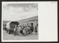 [recto] OUTGOING--Boarding truck at high school to be transported to train. ;  Photographer: Aoyama, Bud ;  Heart Mountain, Wyoming.