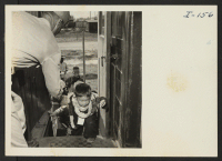 [recto] Closing of the Jerome Center, Denson, Arkansas. Travel is just another adventure to the children of the relocation centers. Here a little tot eagerly mounts the steps of the chair car assisted by a member of the military police. ;  Photographer: Iwasaki