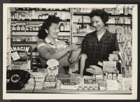[recto] Miss Nobuko Fujiki and Mrs. Herb Schaefer, wife of the proprietor of the Schaefer Pharmacy, are shown at their work ...