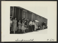 [recto] Part of a line waiting for lunch outside the mess hall at noon. ;  Photographer: Lange, Dorothea ;  Manzanar, California.