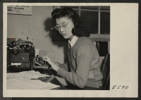 [recto] Reporter Kay Masuda of the Sentinel staff, Heart Mountain Relocation Center 's 8-page tabloid newspaper, which is published entirely by center residents of Japanese ancestry. ;  Photographer: Parker, Tom ;  Heart Mountain, Wyoming.