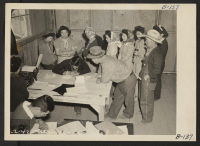 [recto] Manzanar, Calif.--Evacuees of Japanese ancestry signing up for work at this War Relocation Authority center. ;  Photographer: Albers, Clem ;  Manzanar, California.