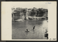 [recto] Manzanar, Calif.--Small evacuee boys enjoying a swim in the mountain creek which flows through the desert on the border of this War Relocation Authority center. ;  Photographer: Lange, Dorothea ;  Manzanar, California.