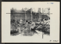 [recto] Manzanar, Calif.--Evacuees enjoying the creek which flows along the outer border of this War Relocation Authority center. ;  Photographer: Lange, Dorothea ;  Manzanar, California.