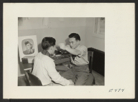 [recto] In the optometry clinic, a resident is fitted with corrective glasses. ;  Photographer: Parker, Tom ;  Amache, Colorado.