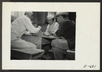[recto] Three evacuees playing the age old Japanese game of Go in the recreation room at this center. ;  Photographer: Stewart, Francis ;  Rivers, Arizona.
