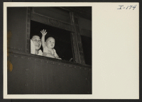 [recto] Closing of the Jerome Center, Denson, Arkansas. A mother and very small infant, occupants of one of the pullman berths, waves goodbye from the car window. ;  Photographer: Iwasaki, Hikaru ;  Denson, Arkansas.