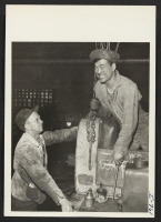 [recto] Harry Yanaga, formerly of Gardena, California, and the Colorado River Center, with a fellow worker at the International Caterpillar Company ...