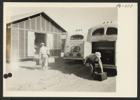 [recto] Site No. 1. Construction employees aided evacuees unload their baggage as they arrived at the relocation center. ;  Photographer: Clark, Fred ;  Poston, Arizona.