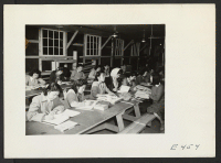 [recto] An adult education class in pattern drafting. The teacher (right) is Miss Okimoto. ;  Photographer: Parker, Tom ;  Amache, Colorado.