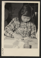 [recto] A young enthusiast working on a pair of book ends in a center craft shop. Craft shops are popular recreation for old as well as young residents of Japanese ancestry at this relocation center. ;  Photographer: Parker, Tom ;  Heart Mountain, Wyoming.