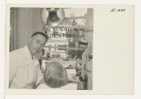 [recto] Dr. V. Sugami (formerly of Minidoka) is shown at work in his dental office, located at 1210 Fourth Street, Sacramento, California. Doctor Sugami's offices have been open for approximately a month now, and he reports business very good. ;  Photographer: