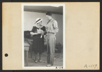 [recto] Poston, Ariz.--Mrs. Lyle Kurisaki, evacuee of Japanese ancestry, and Norris James, WRA official, in an interview at this War Relocation Authority center during a CBS nationwide hookup. ;  Photographer: Clark, Fred ;  Poston, Arizona.