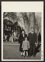 [recto] Mr. and Mrs. Joe Tsuji, formerly of Granada and Los Angeles, with one of their children, Grace, in front of ...