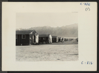 [recto] Manzanar, Calif.--Street at this War Relocation Authority center on a summer evening, showing the barrack apartments. ;  Photographer: Lange, Dorothea ;  Manzanar, California.