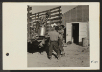 [recto] Daily supply of milk being delivered by young evacuee workers at the mess kitchen door. ;  Photographer: Parker, Tom ;  Topaz, Utah.