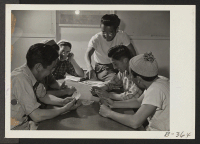 [recto] Members of the fire department spend their leisure time by a friendly game of cards. ;  Photographer: Stewart, Francis ;  Topaz, Utah.