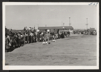 [recto] Arrivals from Tule Lake lined up awaiting induction.--INCOMING ;  Photographer: Aoyama, Bud ;  Heart Mountain, Wyoming.