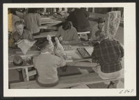 [recto] In a wood carving class, at the Rohwer Relocation Center, center residents (former west coast persons of Japanese ancestry) enthusiastically ...