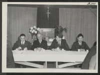 [recto] Rev, E. Stanley Jones, leader of traveling missionary team, enjoys tea during conference at Central Utah Relocation Center at Topaz. The affair was held at Protestant Church. Left to right: Dave Tatsuno, Rev. E. Stanley Jones, Dr. Skoglund, and Rev. Nishi