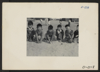 [recto] These youngsters are playing in the field of a nursery school at Manzanar, a War Relocation Authority Center where evacuees of Japanese ancestry will spend the duration. ;  Photographer: Stewart, Francis ;  Manzanar, California.
