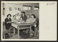 [recto] Japanese-American family makes plans to return to California home. The members of the Shikano family gathers around the crude table ...