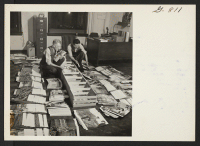 [recto] Chas. Mace and Hikaru Iwasaki of the WRA Photographic Unit, pack 1044 mounted enlargements for distribution to the centers where they will be displayed to promote relocation in the southern area. ;  Denver, Colorado.