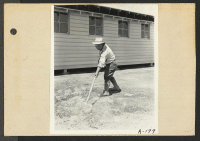 [recto] Poston, Ariz.--Site No. 1. Evacuee of Japanese ancestry at this War Relocation Authority center cleaning up the grounds around the Administration building. ;  Photographer: Clark, Fred ;  Poston, Arizona.