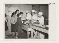 [recto] Mealtime shortly after arrival in April 1942 of first evacuees of Japanese ancestry at Manzanar, now a War Relocation Authority Center. ;  Photographer: Albers, Clem ;  Manzanar, California.