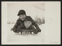 [recto] These two boys are rapidly developing a love for a sport which is entirely new to them . . . sledding. (L to R) Toshio Boi, Henry Kumasaka. Present occupation: students. Former occupation: students. Former residence: Seattle, Washington. ;  Photographer