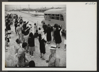 [recto] A crowd of Topaz Center residents wave farewell as one of the buses, City of Topaz, leaves the assembly center on it's way to Delta, Utah, with passengers for trip 15 leaving for Tule Lake. ;  Photographer: Mace, Charles E. ;  Topaz, Utah.
