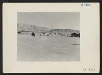 [recto] Manzanar, Calif.--General view of this War Relocation Authority center looking southwest across the wide fire-break which separates blocks of barracks. Evacuees are on their way to breakfast or to work. ;  Photographer: Lange, Dorothea ;  Manzanar, Ca