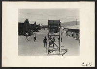 [recto] Tanforan Assembly Center, San Bruno, Calif.--Evacuee boys in the foreground are playing basketball. This is one of eight recreation centers ...