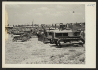 [recto] Closing of the Jerome Center, Denson, Arkansas. Farm equipment assembled in the Jerome motor pool showing trucks and other vehicles assembled for shipment to the Rohwer Center. ;  Photographer: Mace, Charles E. ;  Denson, Arkansas.