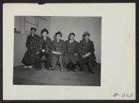 [recto] A group of newly arrived evacuees from Hawaii are pictured in their new barracks homes. These evacuees, upon arrival in San Francisco, were given army issue over coats to protect them from the Utah cold. ;  Photographer: Stewart, Francis ;  Topaz, Uta