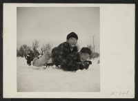 [recto] These two boys are rapidly developing a love for a sport which is entirely new to them . . . sledding. (L to R) Toshio Boi, Henry Kumasaka. Present occupation: students. Former occupation: students. ;  Photographer: Stewart, Francis ;  Hunt, Idaho.