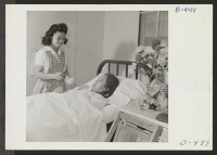 [recto] Nurse's Aid student Cheiko Neeno attends Mrs. Hide Uyeda, a patient in the Poston Hospital. ;  Photographer: Stewart, Francis ;  Poston, Arizona.