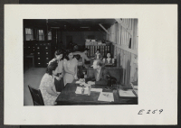 [recto] W. C. Love, Placement Officer, showing assignment desks. ;  Photographer: Parker, Tom ;  Denson, Arkansas.