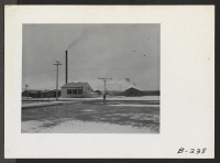 [recto] A winter time view of the central heating plant, which supplies the Tule Lake Hospital with heat and the necessary hot water. The snowy hill in the background is Castle Mountain. ;  Photographer: Stewart, Francis ;  Newell, California.