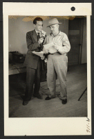 [recto] Announcer Chet Huntley of the CBS interviewing Ellis Georgia, WRA area engineer, in a nationwide hookup. ;  Photographer: Clark, Fred ;  Poston, Arizona.