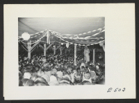 [recto] Two Nisei girls perform a Hawaiian Hula at a block talent show held in the mess hall. Acts include everything from the older Eiseis performing folk lore chants and dances to Nisei renditions of boogie woogie blues on the clarinet or mouth organ. ;  Phot